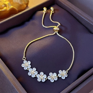 Close-up of gold star flower bracelet with sparkling zircons on purple velvet box