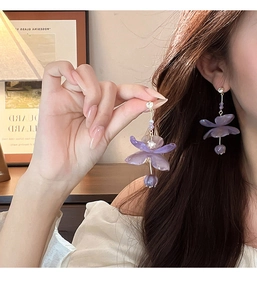 Detailed macro view of purple resin flower earrings with shimmering rhinestones and tassels