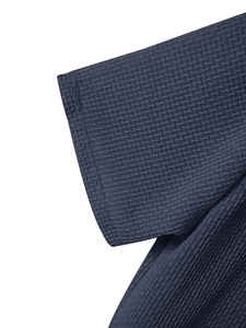 Detailed macro view of navy blue waffle knit fabric and premium stitching on t-shirt hem