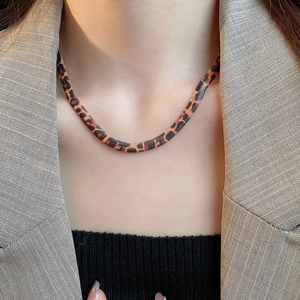 Nahaufnahme einer Schlangenknochenkette mit Leopardenmuster und orange-schwarzer Textur