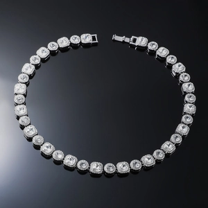 Close-up of hip hop square link chain with clear crystals and secure clasp on black surface