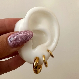 Three-piece set of gold titanium steel hoop earrings in small, medium, and large sizes