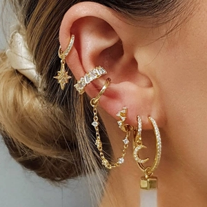 Detailed close-up of S925 silver gold-plated cartilage earrings with sparkling star and moon charms