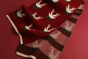 Detailed close-up of Christmas knit scarf showing reindeer pattern and plaid texture