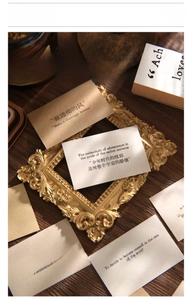 Detail of vintage textured paper cards with bilingual inspirational typography and gold frame