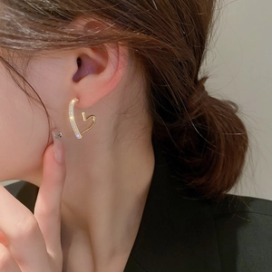 Elegant gold-plated heart hoop earrings with sparkling cubic zirconia on a female model