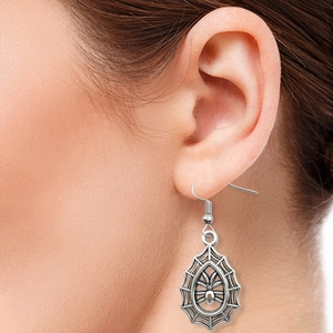 Gothic silver spider web earring with spider charm worn on ear for Halloween style