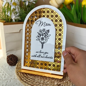 Detail of white acrylic Mom heart sign with gold accents and floral we love you text