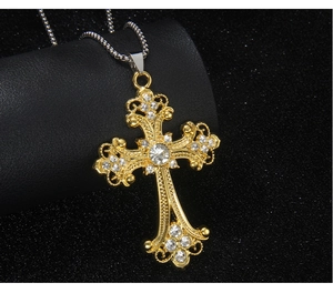 Close-up of hip hop gold cross pendant with sparkling rhinestones and silver chain