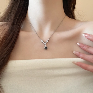 Dettaglio macro della collana in argento a V con pietra quadrata nera e cristalli chiari