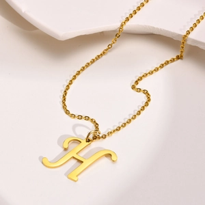Detailed close-up of a gold-plated letter H pendant on a minimalist necklace chain