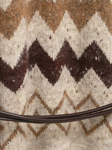 Close-up of chevron knit fabric with sequin detail and decorative brown tie strap