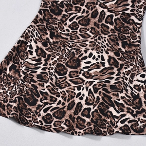 Close-up of leopard print fabric texture and curved hem on a slim-fit mini dress