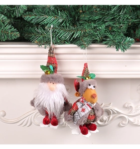 Detailed close-up of plush Santa and reindeer Christmas ornaments with festive pine backdrop