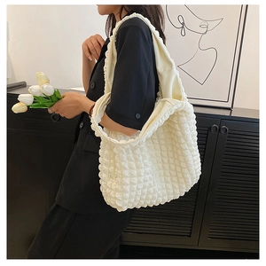 White puffer tote bag with floral texture and wavy shoulder strap on model