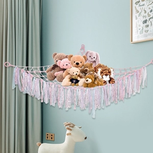 Pink handmade woven toy hammock with fringe tassels for nursery plush storage