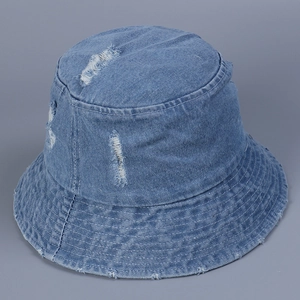 Détail d'un bob en jean vieilli avec bords effilochés et finition délavée vintage