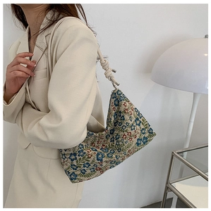 Detail of floral jacquard canvas hobo bag with cream leather strap and knot design