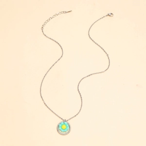 Detail of sunflower pendant necklace with a green daisy charm on a silver chain link