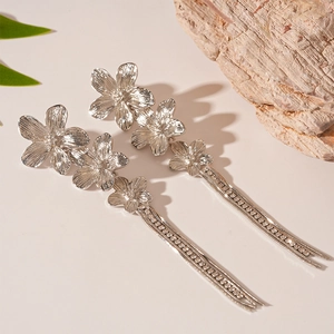 Close-up of silver metal flower earrings with sparkling rhinestone fringe tassels