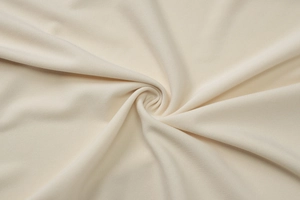 Gros plan sur le tissu en maille crème montrant la texture douce et le drapé dense
