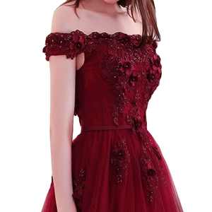 Détail de la broderie en dentelle florale 3D sur une robe de soirée bordeaux à épaules nues
