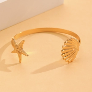 Brazalete abierto dorado con diseño de estrella de mar y concha, estilo oceánico
