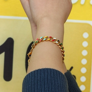 Detailed shot of golden Cuban chain bracelet with vibrant colorful enamel drip details