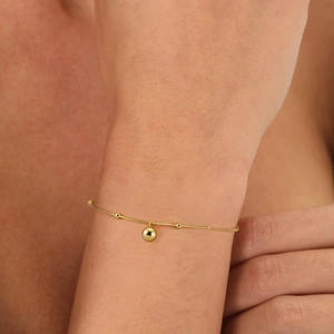 Detailed close-up of 18K gold-plated 925 silver beaded chain bracelet with ball charm