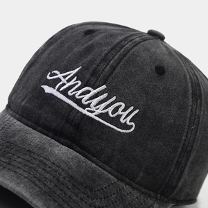 Close-up of Andyou 3D white embroidery on vintage washed black cotton baseball cap