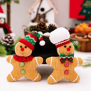 Close-up of plush gingerbread man Christmas ornaments with corduroy texture and festive hats