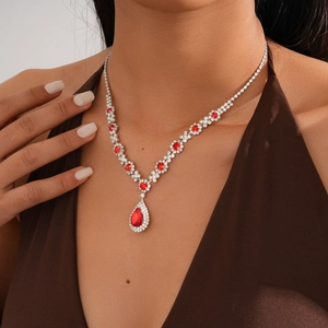 Close-up of luxury silver necklace with red teardrop pendant and sparkling diamonds