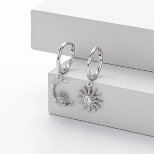 Detail of S925 sterling silver asymmetrical earrings with moon and sun star zircon charms