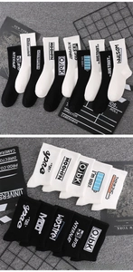 Close-up of black and white crew socks featuring graphic text and ribbed cotton texture
