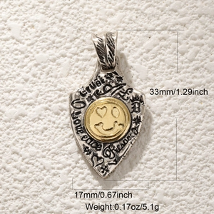 Détail du pendentif bouclier avec crâne, dimensions de 33mm et visage souriant doré
