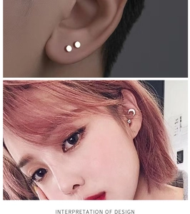 Close-up view of a model wearing minimalist stainless steel round disc and moon stud earrings.