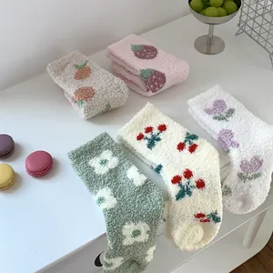 Flat lay of five pairs of warm coral fleece socks with floral and fruit patterns