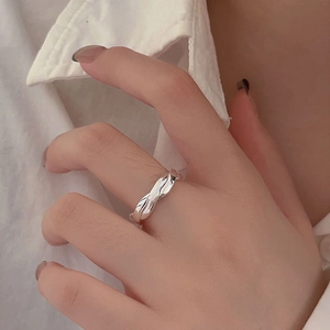 Close-up of a sterling silver twisted ring worn on hand with minimalist wavy texture