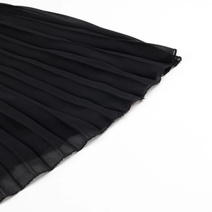 Detail of black pleated chiffon fabric with raw edges on long lace slip dress