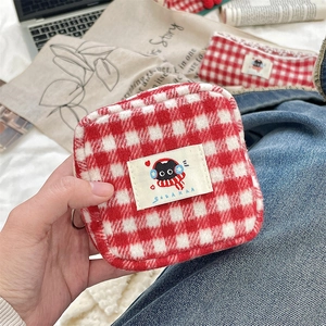 Close-up of red plaid wool storage pouch with cute cat patch and soft plush texture