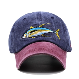 Detailed close-up of tuna fish embroidery on washed navy cotton baseball cap