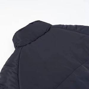Detailed view of dark blue reversible puffer jacket collar and padded shoulder fabric