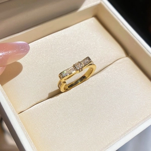 Detailed close-up of a gold bow ring with micro-pave zircons in a velvet box