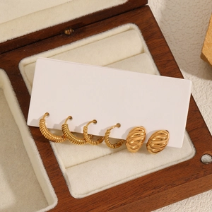 Three pairs of twisted and ribbed 18k gold plated stainless steel hoop earrings in a box