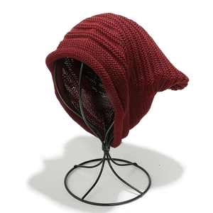 Close-up of chunky knit texture on wine red slouchy beanie for women outdoors