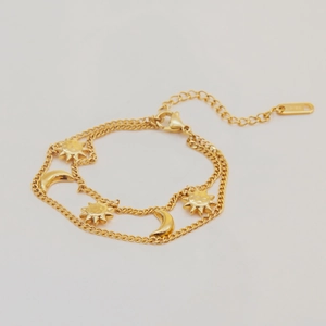 Detail of 18K gold-plated double-layer bracelet with sun and moon charms and lobster clasp