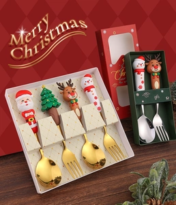 Close-up of golden Christmas spoons with 3D Santa and reindeer handles in a festive gift box