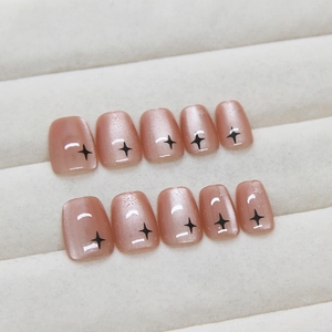 Pink cat eye press-on nails with sparkling black star patterns in short square shape