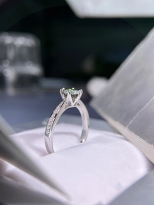 Macro shot of 925 silver ring with 4-prong set round moissanite and side stones