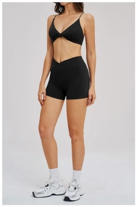 Detail of black sports set with knot-front bra and cross-waist high-stretch shorts